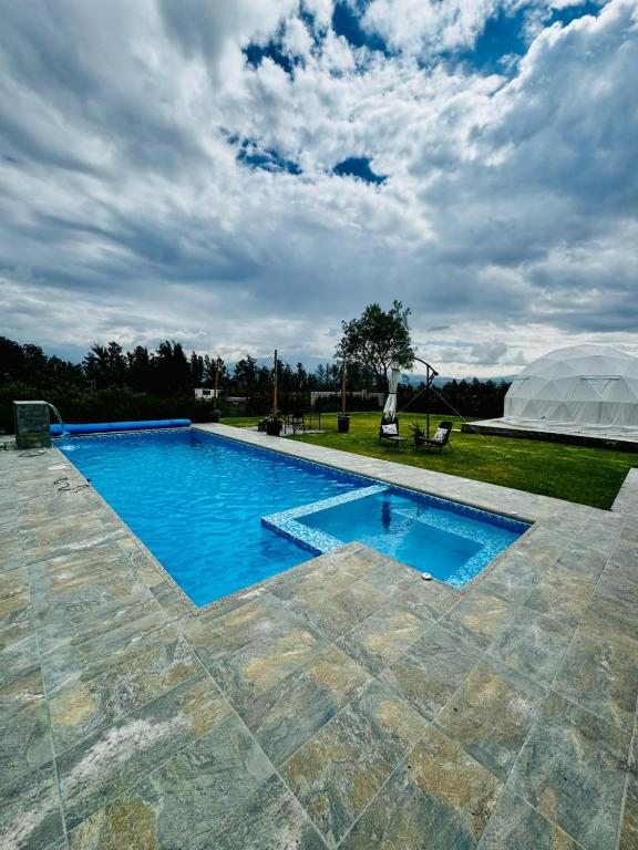 Piscina, jardines y zona de glamping en Quinta Paco de Lucía